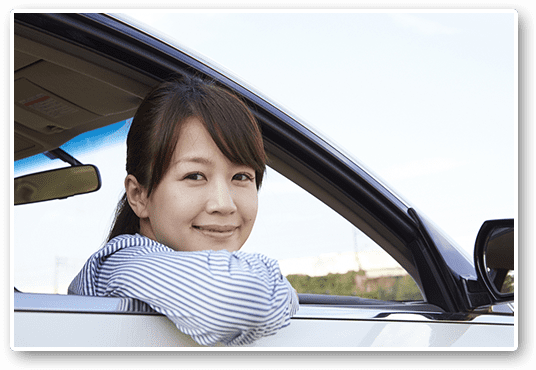 車の窓から笑顔を見せる女性